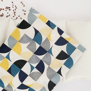 May include: Two white linen flax seed heating pads, one with a geometric pattern of blue, yellow, and black circles, and one with a plain white surface.