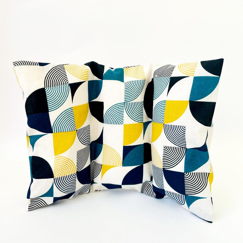 May include: Three decorative throw pillows with a geometric pattern of blue, yellow and black semi-circles on a white background.