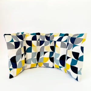 May include: A set of four decorative cushions with a geometric pattern in shades of blue, yellow, and white. The cushions are arranged in a curved shape.