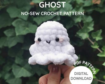 Könnte beinhalten: Ein weißer, nahtloser Häkelgeist mit einem lächelnden Gesicht und rosa Akzenten. Das Bild enthält den Text "GHOST" und "NO-SEW CROCHET PATTERN". Ein PDF-Muster zum Herunterladen ist verfügbar.