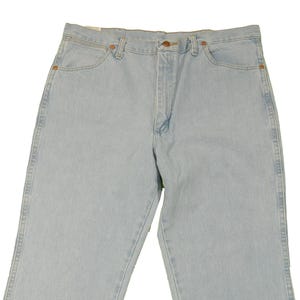 Op de afbeelding: Lichtblauwe spijkerbroek met een knoopsluiting en riemlussen. De broek heeft een rechte pijp en is gemaakt van een zachte, comfortabele stof.