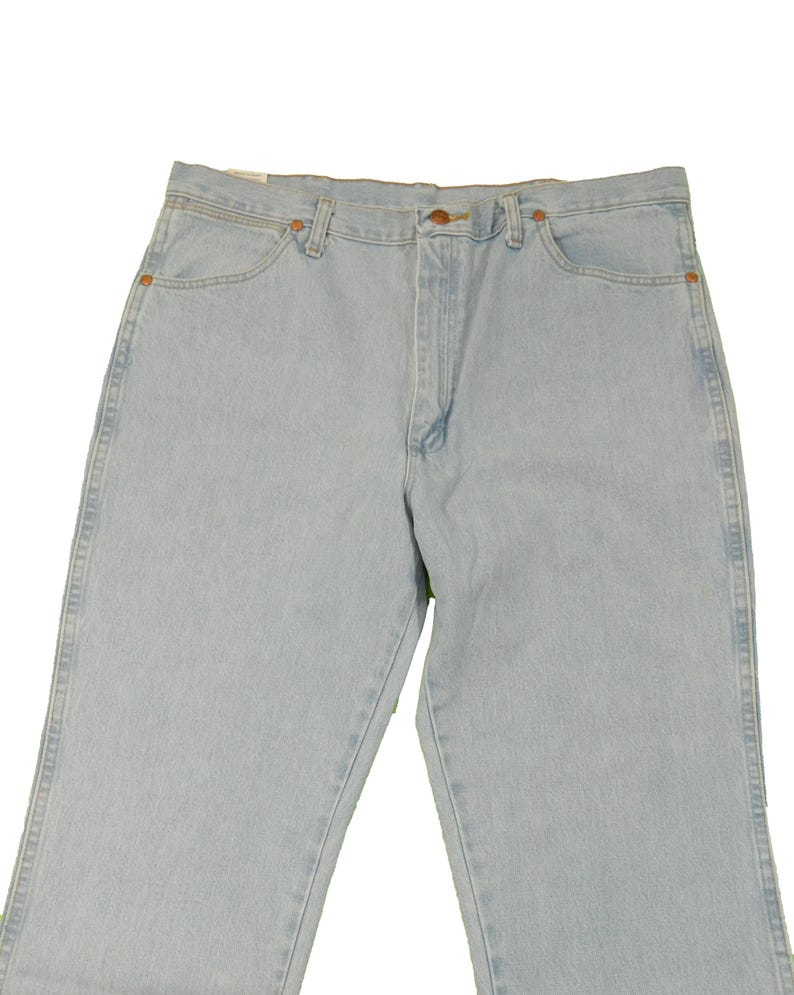 Op de afbeelding: Lichtblauwe spijkerbroek met een knoopsluiting en riemlussen. De broek heeft een rechte pijp en is gemaakt van een zachte, comfortabele stof.