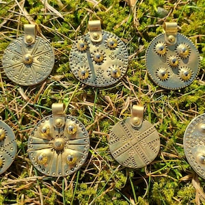 Viking Age Handstamped Shield Pendant Daugmale Hillfort Livonian Sun symbol.