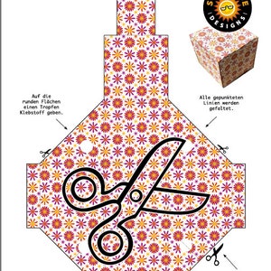 May include: A printable craft template for a gift box with a floral pattern. The template includes instructions for folding and cutting the paper to create the box. The text on the template reads "Bastelbogen Papier-Geschenkschachtel" and "SxUxNxJ+ Designs".