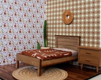 May include: A miniature dollhouse bedroom with a wooden bed, a brown rug, a nightstand, and two potted cactus plants. The walls are covered in patterned wallpaper.