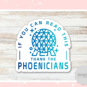 May include: A die-cut sticker featuring a blue gradient geodesic sphere icon centered above the text "IF YOU CAN READ THIS THANK THE PHOENICIANS" in a bold sans-serif font. The design includes small geometric accents and sparkles.