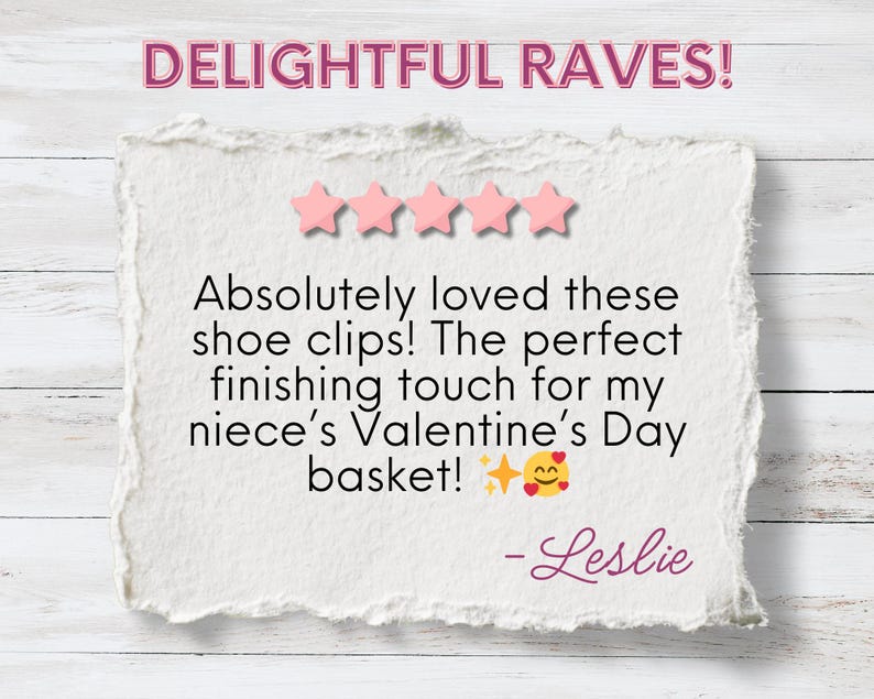 The image features a positive review titled "DELIGHTFUL RAVES!" displayed in bold pink text, accompanied by a five-star rating. The review reads: "Absolutely loved these shoe clips! The perfect finishing touch for my niece’s Valentine’s Day basket! ✨😍" and is signed by Leslie. The background has a clean white texture, giving the presentation a polished and cheerful vibe.
