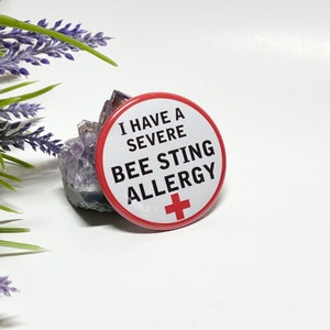 May include: A white button with a red border and a red cross in the bottom right corner. The button says "I have a severe bee sting allergy".