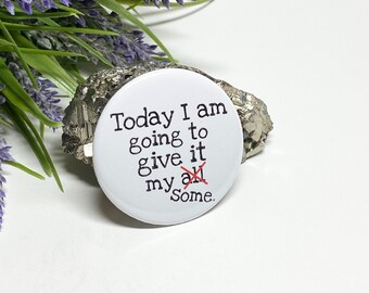 May include: White button with black text that reads "Today I am going to give it my all" with the word "all" crossed out and replaced with "some".