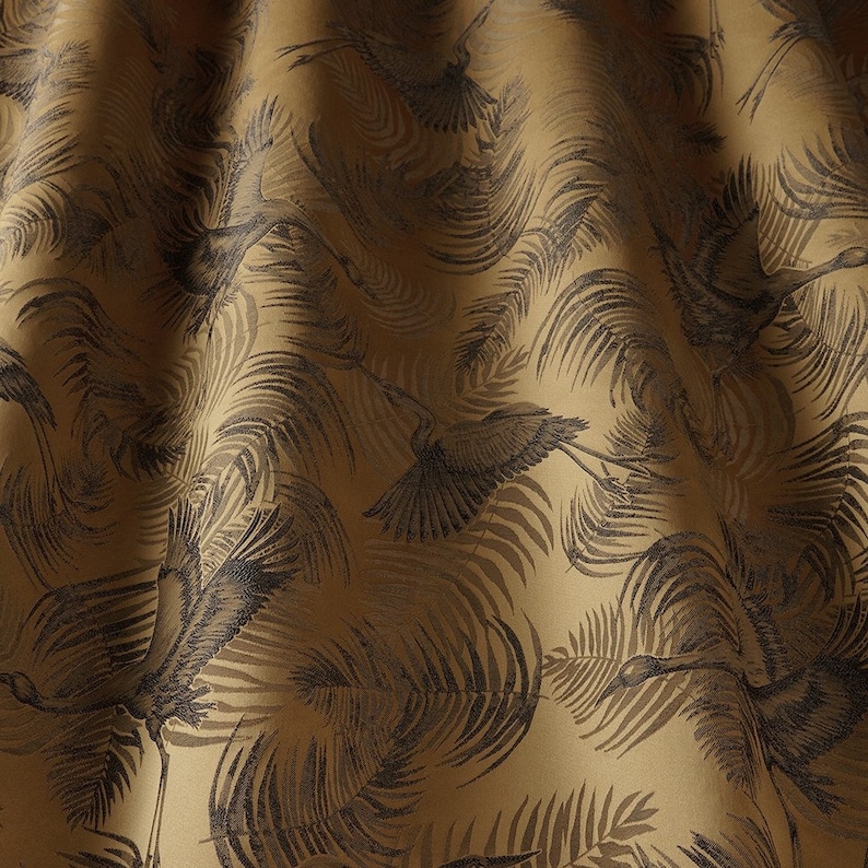 Peut inclure: Un tissu dor&eacute; avec un motif noir et blanc d'oiseaux et de feuilles. Le tissu a une surface textur&eacute;e.