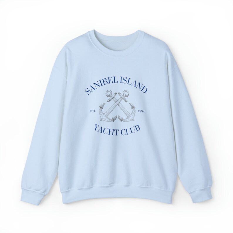 May include: Light blue sweatshirt with a navy blue graphic of two crossed anchors and the text "Sanibel Island Yacht Club Est. 1954".