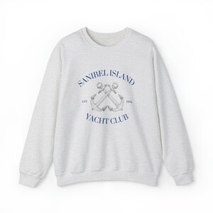 May include: A heather gray sweatshirt with a navy blue logo that says "Sanibel Island Yacht Club" with two crossed anchors and the text "Est. 1954".