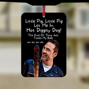 May include: A black and white car air freshener with a picture of a man holding a baseball bat. The text on the air freshener reads "Little Pig, Little Pig Let Me In. Hot Diggity Dog! This Kind Of Thing Just Tickles My Balls dun dun dun dah"