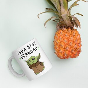 May include: White ceramic mug with a green cartoon character and the text "Yoda Best Grandad" in black lettering.