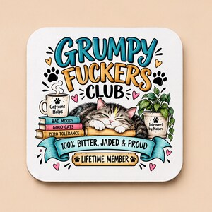 Peut inclure: Un dessous de verre carré illustré d'un chat tigré endormi sur des livres. Le texte indique : GRUMPY FUCKERS CLUB, Caffeine Helps, Bad Moods, Good Cats, Zero Tolerance, Introvert by Nature, 100% Bitter, Jaded & Proud et Lifetime Member avec des pattes.