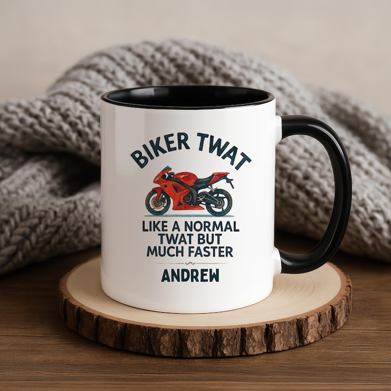May include: White ceramic mug with a black interior and handle. The mug features the text "BIKER TWAT" above a red motorcycle graphic. Below the graphic is the text "LIKE A NORMAL TWAT BUT MUCH FASTER" and the name "ANDREW".