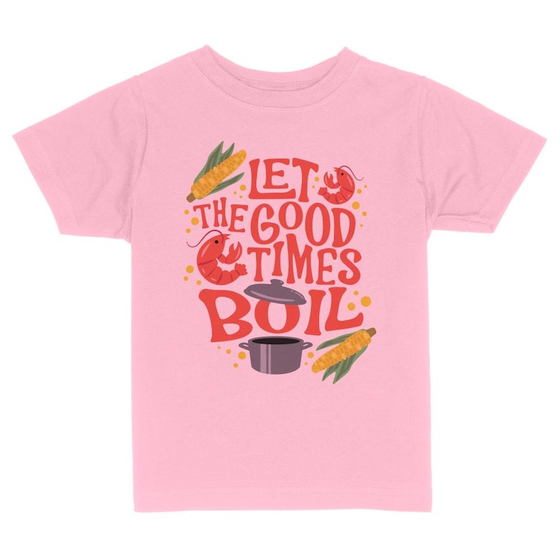 May include: Pink kids' t-shirt with a graphic design of a pot, corn, and crawfish with the text "Let the good times boil."