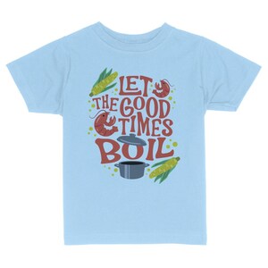 May include: Light blue t-shirt with a graphic design of a pot, corn, and crawfish with the text "Let the good times boil."