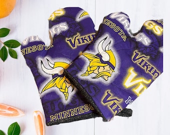May include: Two purple and gold oven mitts with the Minnesota Vikings logo and the words "Minnesota Vikings" and "Skol Vikings".