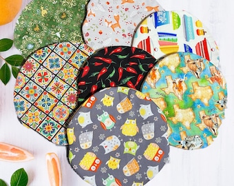 May include: Set of 10 colorful fabric round placemats with various designs. The placemats feature a variety of patterns, including floral, geometric, and animal prints. The placemats are perfect for adding a touch of style to any dining table.