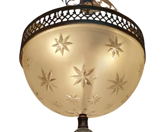 May include: A frosted glass ceiling light fitting with a brass frame and a starburst pattern. The fitting has a decorative finial at the bottom.