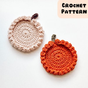 Könnte beinhalten: Zwei handgefertigte gehäkelte Kürbis-Untersetzer. Einer ist hellbeige mit einem braunen Stiel, der andere ist orange mit einem grünen Stiel. Die Untersetzer sind rund mit einem strukturierten Rand. Der Text "CROCHET PATTERN" befindet sich oben rechts.