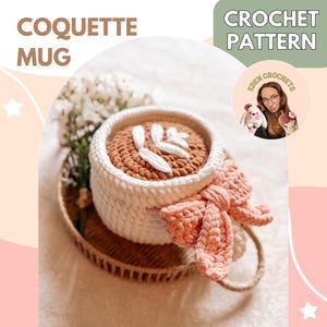May include: A handmade crochet mug with a white exterior and a brown interior, adorned with white leaf-shaped embellishments. A peach-colored bow is attached to the side. The text "COQUETTE MUG" and "CROCHET PATTERN" are visible.