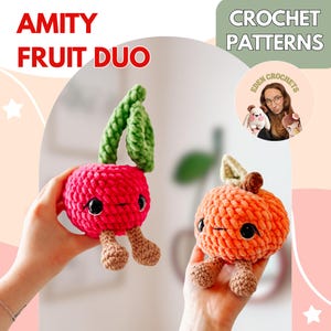 May include: Two crocheted fruit toys, one red and one orange, each with black eyes and small legs. The red fruit has green leaves, and the orange fruit has a tan stem and leaf. The text "AMITY FRUIT DUO" and "CROCHET PATTERNS" are visible.