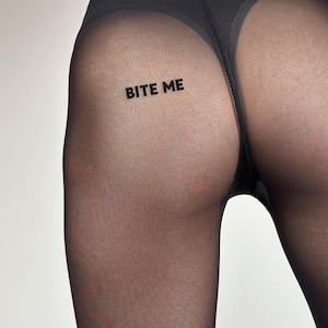 May include: Black sheer tights with the phrase "BITE ME" printed in capital letters on the rear. The tights are opaque in the waistband and crotch area, becoming sheer on the legs.