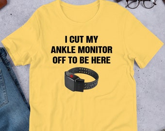 May include: Yellow t-shirt with the text "I cut my ankle monitor off to be here" and a black ankle monitor graphic.