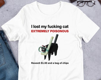 Peut inclure: T-shirt blanc avec du texte noir qui dit "J'ai perdu mon chat putain EXTREMEMENT VENENEUX". Un chat noir avec un bâton de hockey et un masque facial vert est représenté sur le t-shirt. Le texte "Récompense : 1,50 € et un sac de chips" est imprimé sous l'image.