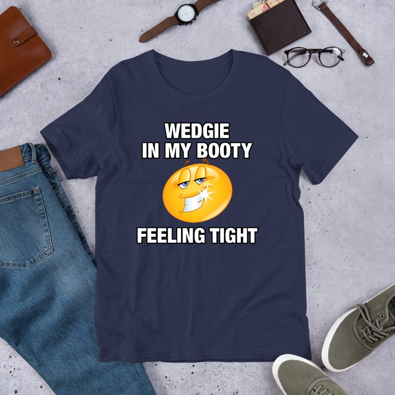 May include: A navy blue t-shirt with a yellow smiley face and the text "WEDGIE IN MY BOOTY FEELING TIGHT"