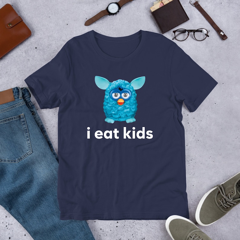 May include: A navy blue t-shirt with a blue fuzzy creature with big eyes and the text "i eat kids" printed on it.