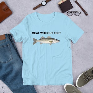 May include: Light blue t-shirt with a striped fish illustration and the text "MEAT WITHOUT FEET" printed on the front.
