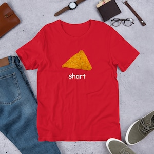 May include: Red short-sleeved t-shirt with a yellow tortilla chip graphic and the word "shart" printed in white.