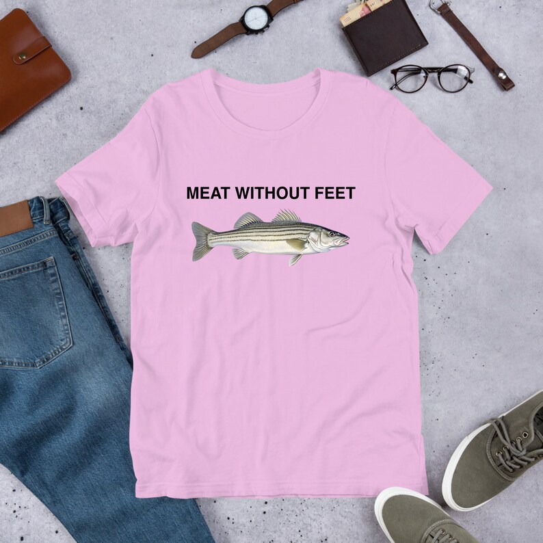 May include: Pink short-sleeved t-shirt with a black and white striped fish illustration and the text "MEAT WITHOUT FEET" printed on the front.