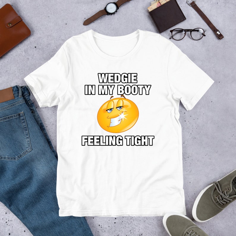 May include: White t-shirt with a yellow smiley face and the text "WEDGIE IN MY BOOTY FEELING TIGHT"