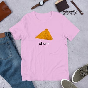May include: A pink t-shirt with a picture of a nacho chip and the word "shart" printed on it.