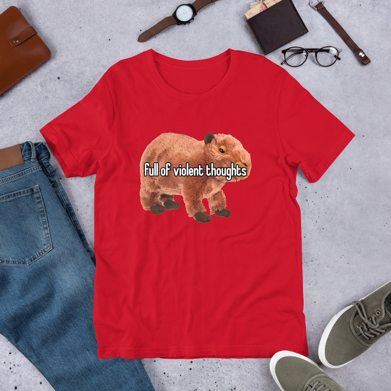 May include: Red short-sleeved t-shirt with a brown capybara illustration and the text "Full of violent thoughts".