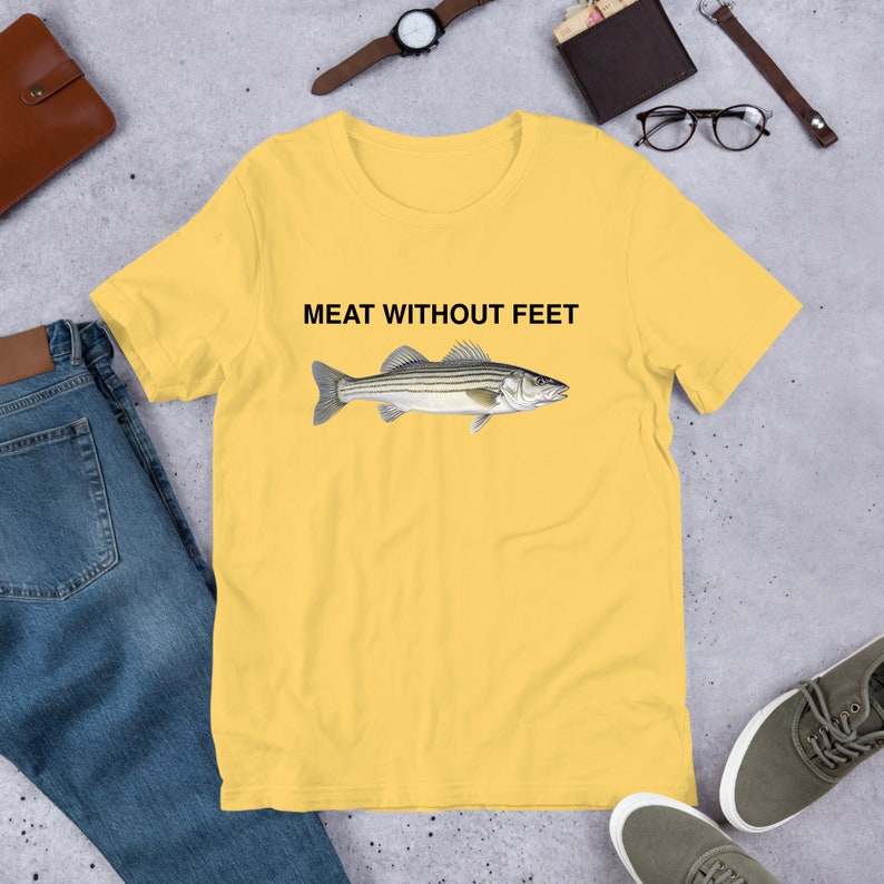 May include: Yellow short-sleeved t-shirt with a black and white striped fish illustration and the text "MEAT WITHOUT FEET" printed on the front.