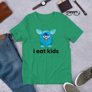 May include: A green t-shirt with a blue fuzzy creature with big eyes and the text "i eat kids" printed on it.