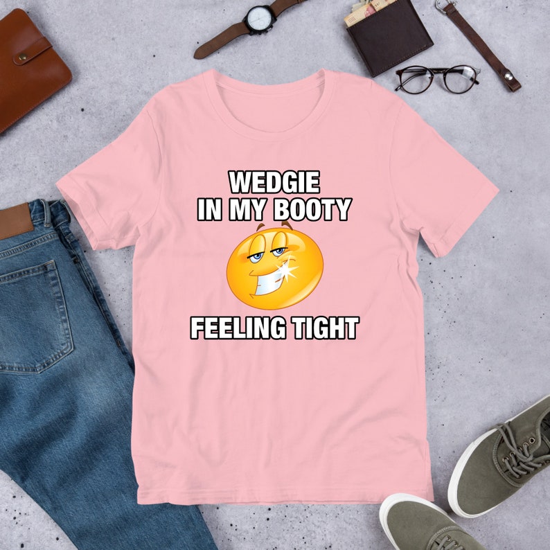 May include: Pink t-shirt with a yellow smiley face and the text "WEDGIE IN MY BOOTY FEELING TIGHT"