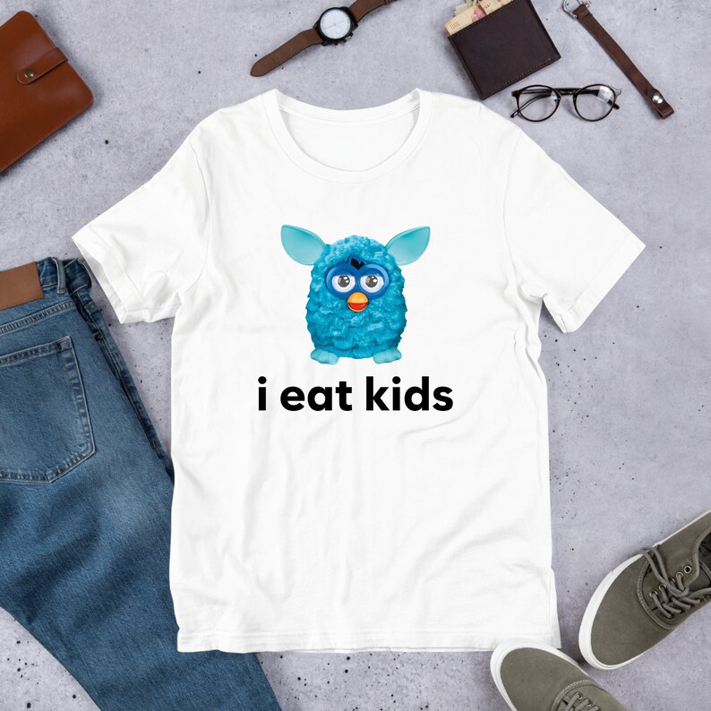 May include: White t-shirt with a blue fuzzy creature with big eyes and the text "i eat kids" printed on it.