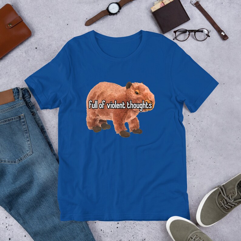 May include: A royal blue t-shirt with a brown capybara wearing a white shirt with the text "Full of violent thoughts" printed on it.