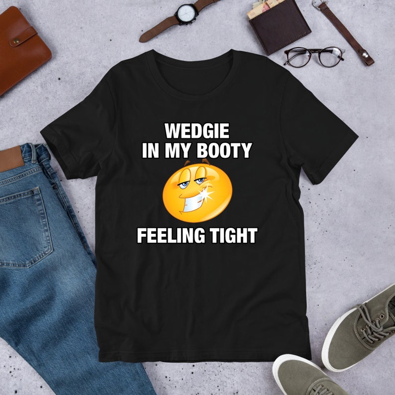 May include: Black t-shirt with a yellow smiley face and the text "WEDGIE IN MY BOOTY FEELING TIGHT"