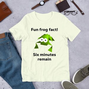 May include: A light yellow t-shirt with a green cartoon frog and the text "Fun frog fact! Six minutes remain".