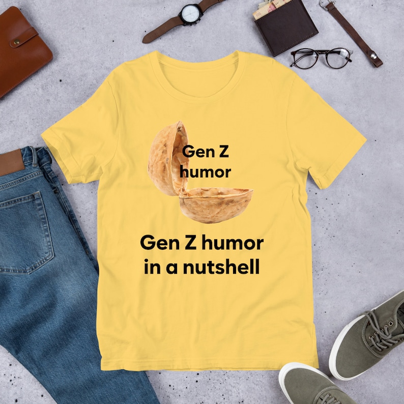 May include: Yellow t-shirt with a graphic of a walnut with the text "Gen Z humor" above it and "Gen Z humor in a nutshell" below it.