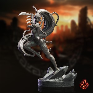 May include: A grey fantasy figurine of a warrior with long flowing hair, wearing segmented armor and wielding a curved blade. The figure is posed in a dynamic leap, attached to a circular base with rocky textures and a small flame icon in the corner.