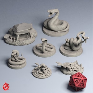 Puede incluir: Una colección de figuras en miniatura grises sin pintar que muestran varias serpientes en poses enroscadas y de ataque, una pieza de terreno rocoso, un nido con huevos y un dado rojo de veinte caras. Las figuras tienen detalles.