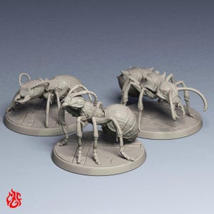 May include: Three unpainted grey miniature ant figurines standing on circular bases with a stone-like texture. Each ant features detailed segmented bodies, prominent mandibles, and long antennae, captured in a static pose on a plain background.